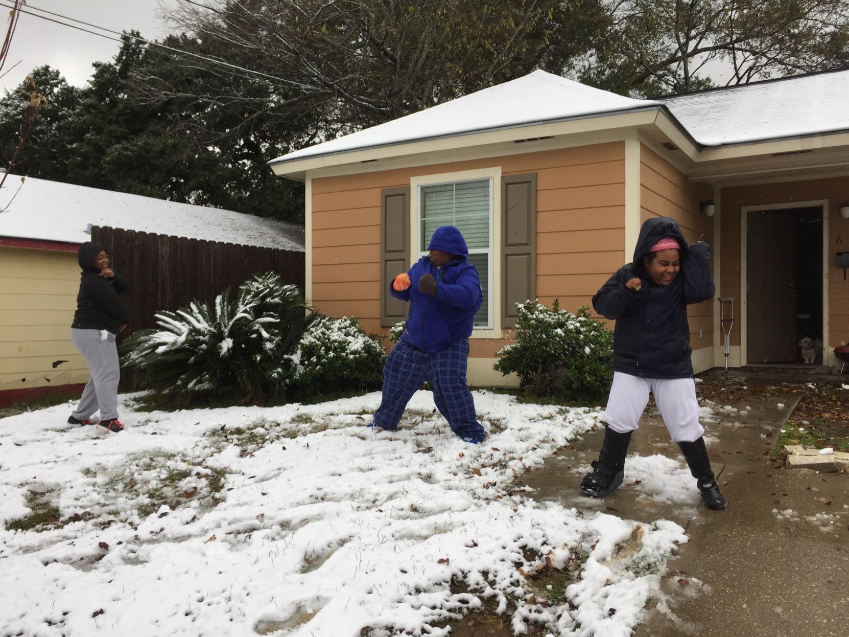 Kalisha James, 26, and her nephew Christopher Honore, 14, and niece Tayelor Honore, 11, have a snowball fight in front of their Washington Street home.